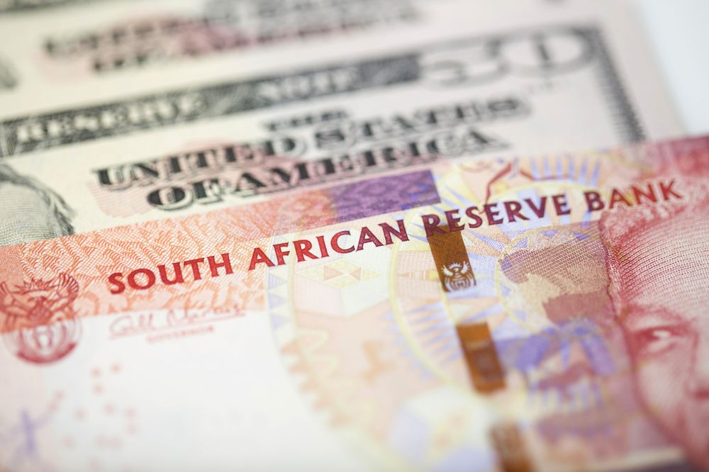 South African Rand notes sit on American fifty dollar notes.
